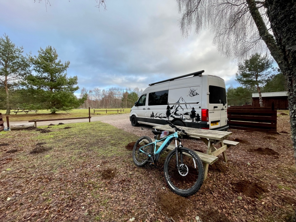 Camper van and bike parked up at campsite 